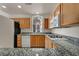 Efficient kitchen with wood cabinets, granite counters, gas range, and modern appliances, bright lighting at 23 E Agate Ave # 308, Las Vegas, NV 89123
