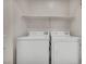 Convenient laundry area features a washer, dryer, and overhead shelving for storage at 23 E Agate Ave # 308, Las Vegas, NV 89123