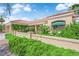 Exterior elevation displays vibrant landscaping, stucco wall, and covered arched entryway at 2825 Brianwood Ct, Las Vegas, NV 89134
