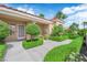 Inviting covered front entrance surrounded by verdant, manicured greenery and a glass panel front door at 2825 Brianwood Ct, Las Vegas, NV 89134