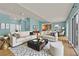 Bright, staged living room area with light blue walls, plush sofas, and seamless access to kitchen and dining at 2825 Brianwood Ct, Las Vegas, NV 89134