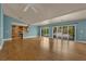 Spacious living room featuring hardwood floors, a ceiling fan, backyard access, and an adjacent kitchen at 2825 Brianwood Ct, Las Vegas, NV 89134