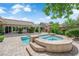 Beautiful backyard featuring a pool, spa, patio, outdoor fireplace and mature trees at 2825 Brianwood Ct, Las Vegas, NV 89134