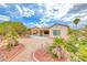 Well-maintained backyard with desert landscaping, a covered patio, and mature trees at 3050 Canal Walk Rd, Henderson, NV 89052