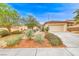 Charming single-story home with desert landscaping, a two-car garage and a long driveway at 3050 Canal Walk Rd, Henderson, NV 89052