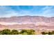 Wide scenic view of a mountain range under a blue sky, with tiled roofs and trees in the foreground at 3050 Canal Walk Rd, Henderson, NV 89052