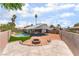 A spacious backyard featuring an in-ground pool, fire pit area, and a low-maintenance landscape with artificial turf at 3086 Cardinal Dr, Las Vegas, NV 89121