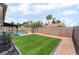 A backyard features a pristine pool and artificial turf, complete with rock ground cover, merging leisure and easy upkeep at 3086 Cardinal Dr, Las Vegas, NV 89121