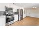 Modern kitchen with stainless steel appliances, gray backsplash, and wood flooring, adjacent to dining area at 3086 Cardinal Dr, Las Vegas, NV 89121