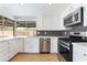 Bright kitchen featuring modern appliances, white cabinetry, and a view of the backyard at 3086 Cardinal Dr, Las Vegas, NV 89121