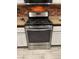 The kitchen has a stainless steel range and white cabinets with a brick-style backsplash at 3128 Spring City Ave, North Las Vegas, NV 89081