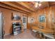 Charming kitchen with stainless steel appliances, wood walls, and eating nook with table at 4581 Aspen Ave, Mount Charleston, NV 89124