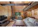 Inviting living room showcasing a wood-burning stove, wood-paneled walls, and comfortable seating at 4581 Aspen Ave, Mount Charleston, NV 89124