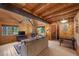 Cozy living room with wood paneled walls and exposed beams, offering a warm and inviting atmosphere at 4581 Aspen Ave, Mount Charleston, NV 89124