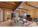 Spacious living room showcasing exposed wood beams, wood paneling, and comfortable seating at 4581 Aspen Ave, Mount Charleston, NV 89124