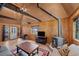 Bright living room featuring exposed wood beams, wood paneling, and comfortable seating at 4581 Aspen Ave, Mount Charleston, NV 89124