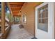 Long covered porch showing an exterior view with white door, rustic feel and surrounding foliage at 4581 Aspen Ave, Mount Charleston, NV 89124