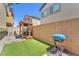 Backyard patio with pavers, a pergola, artificial turf and BBQ provide a great outdoor living space at 4725 Blaise Ave # 103, North Las Vegas, NV 89084