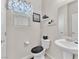 Cozy powder room featuring a pedestal sink, toilet, decor, and wood-look flooring at 4725 Blaise Ave # 103, North Las Vegas, NV 89084