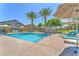 Sparkling community pool surrounded by palm trees, lounge chairs, and umbrellas, perfect for relaxation at 4725 Blaise Ave # 103, North Las Vegas, NV 89084