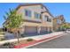 Two-story home featuring neutral paint, attached garages, small balcony, and a tile roof at 4725 Blaise Ave # 103, North Las Vegas, NV 89084