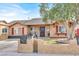 Attractive home with a landscaped front yard, stone accents, red shutters, and mature tree at 5005 Harmony Ave, Las Vegas, NV 89107