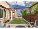 Cozy backyard featuring a pergola with string lights, artificial turf, and patio furniture for outdoor enjoyment at 5023 Salt River Ave, Las Vegas, NV 89139