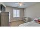 Neutral-toned bedroom with a dresser, TV, and a white bookshelf for storage at 5023 Salt River Ave, Las Vegas, NV 89139