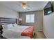 Brightly lit bedroom with a wooden headboard, a TV, and large window at 5023 Salt River Ave, Las Vegas, NV 89139