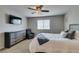 Relaxing bedroom with a ceiling fan, tv, dresser, chair, and comfortable bed at 5023 Salt River Ave, Las Vegas, NV 89139