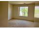 A simple and clean bedroom with carpet, a window view, and neutral paint at 5147 Progresso St, Las Vegas, NV 89135