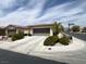 Home exterior featuring multiple garage doors, an extra wide driveway, and desert landscaping at 5147 Progresso St, Las Vegas, NV 89135