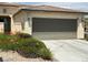 Home garage with a driveway, desert landscaping, and green foliage at 5147 Progresso St, Las Vegas, NV 89135