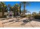 Inviting outdoor seating area with stone fireplace, surrounded by tables, chairs, and meticulously maintained landscaping at 5147 Progresso St, Las Vegas, NV 89135