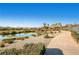 Picturesque lakeside view featuring a paved walking path, lush landscaping, and tranquil pond views at 5147 Progresso St, Las Vegas, NV 89135