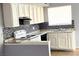 Bright kitchen features white cabinetry, tiled backsplash, sleek countertops, and modern appliances at 5155 Gray Ln, Las Vegas, NV 89119