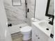 Bright bathroom featuring a glass door shower and white marble tile with black hardware at 532 N 9Th St, Las Vegas, NV 89101