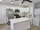 Bright kitchen features stainless steel appliances, white cabinets, and a center island with quartz countertops at 532 N 9Th St, Las Vegas, NV 89101
