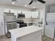 Bright kitchen features stainless steel appliances, white cabinets, and an island with quartz countertop at 532 N 9Th St, Las Vegas, NV 89101
