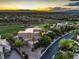 Expansive home on a lush green golf course with a picturesque sunset view of the mountains and city skyline at 583 Saint Croix St, Henderson, NV 89012