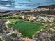 Scenic aerial view showcases luxury homes lining a green golf course against a backdrop of majestic mountains and a serene sky at 583 Saint Croix St, Henderson, NV 89012
