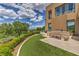 A pristine backyard features a built-in grill and an outdoor seating area with pavers, manicured shrubs, and a large shade tree at 583 Saint Croix St, Henderson, NV 89012