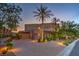 Beautifully landscaped home with a circular driveway, mature trees, and elegant exterior lighting at 583 Saint Croix St, Henderson, NV 89012