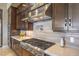 Gourmet kitchen featuring a stainless steel range hood, custom cabinets, and a gas cooktop at 583 Saint Croix St, Henderson, NV 89012