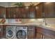 Well-organized laundry room with dark wood cabinets, modern washer and dryer, and a countertop workspace at 583 Saint Croix St, Henderson, NV 89012