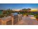 Outdoor kitchen complete with a grill, counter space, cabinets, and a beautiful sunset view at 583 Saint Croix St, Henderson, NV 89012