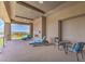 Covered patio area with comfortable lounge chairs, an outdoor fireplace, and scenic views at 583 Saint Croix St, Henderson, NV 89012