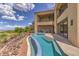 A luxurious backyard pool and spa featuring multiple seating areas, landscaping and an upper balcony overlooking the yard at 583 Saint Croix St, Henderson, NV 89012