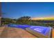 Gorgeous pool and hot tub with illuminated water, lush landscaping, and views of the surrounding landscape at 583 Saint Croix St, Henderson, NV 89012
