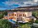 Luxury home with a private pool, outdoor fireplace, covered balcony, and expansive windows offering stunning views of hillside at 583 Saint Croix St, Henderson, NV 89012